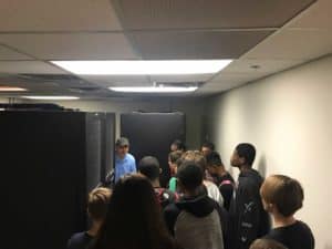 Students near server stack with industry professional